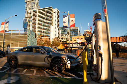 January 20th , 2022 - Austin , Texas , USA: All Electric Porsche Taycan charging at a DC fast charging Electric vehicle charging station powered by Chargepoint in downtown Austin Texas