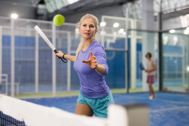 스포티 한 여자 파델 선수 하드 코트에 라켓으로 공을 치는 선수 - racket ball indoors competition 뉴스 사진 이미지