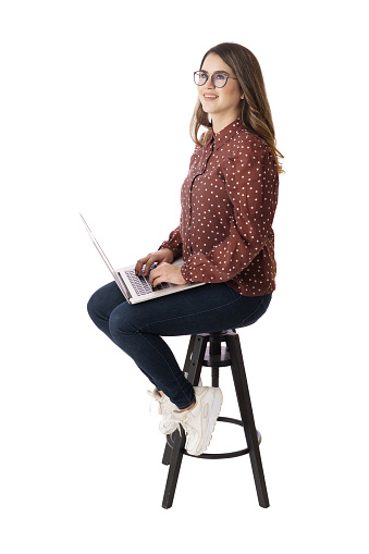 A female student sitting while using a laptop computer and looking up.