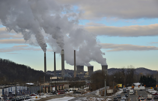 A coal fired power plant in Nitro, West Virginia,USA with smokestacks and cooling towers. The cooling towers letting off steam while the smokestacks belch out CO2 by the ton