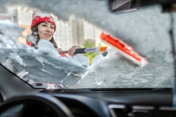 밀레니엄 여성 겨울 재킷 자동차 창문에서 얼음과 눈을 긁어 - snow car window ice scraper 뉴스 사진 이미지