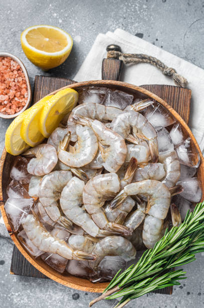 istock Uncooked Raw peeled tiger white shrimp prawn. Gray background. Top view 1367895241