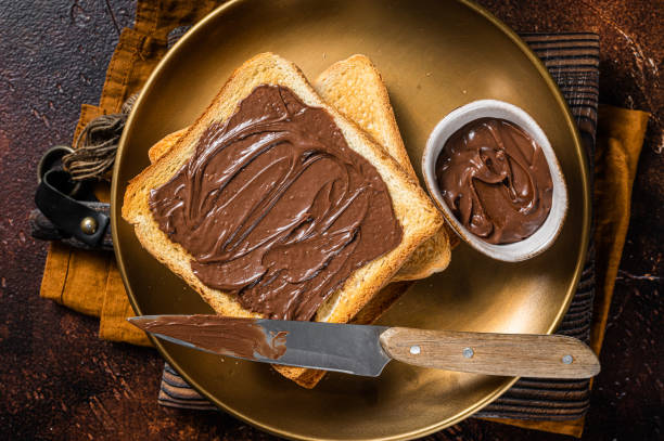 istock Stack of Toasts with chocolate Hazelnut cream in plate. Dark background. Top view 1367895941