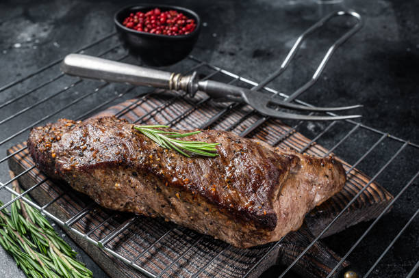 bbq bistecca di manzo alla griglia su una griglia. sfondo nero. vista dall'alto - roast sirloin foto e immagini stock