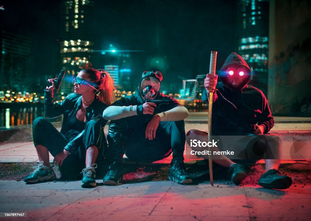 Cyberpunk gang, group of people in futuristic neon lit city Metaverse Stock Photo