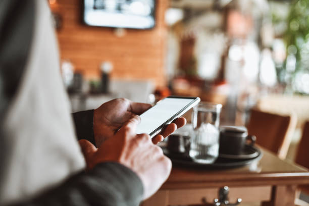 istock Side View Of Waiter Ordering Himself Nice Lunch On Smartphone During Work Break 1367898663