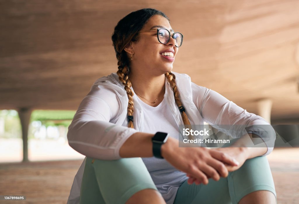 Shot of a sporty young woman taking a break while exercising outdoors I feel a lot happier too Healthy Lifestyle Stock Photo