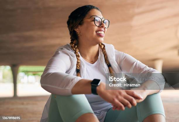Shot Of A Sporty Young Woman Taking A Break While Exercising Outdoors Stock Photo - Download Image Now