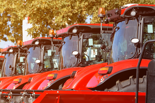 Agricultural tractors aligned outdoor at farming fair, selective focus