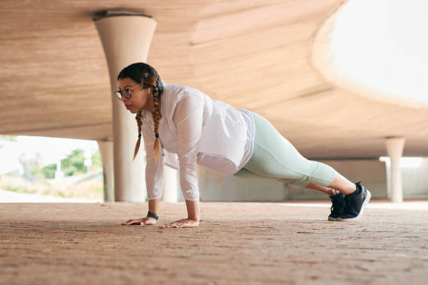 Shot of a sporty young woman doing pushup exercises outdoors You have to work hard for yourself plank ripl fitness