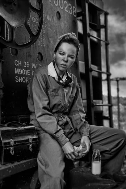 vintage špinavá dělnice, která má přestávku na oběd a sedí na vlakovém vagónu - láhev mléka fotky - stock snímky, obrázky a fotky