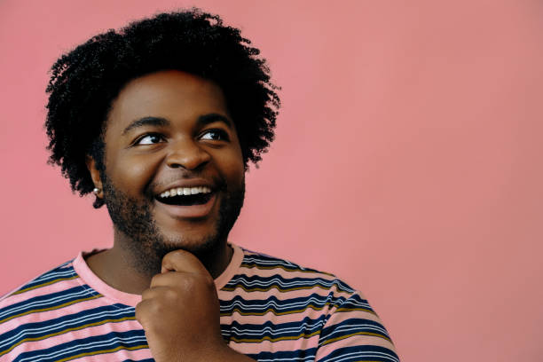 istock young happy african american man posing in the studio over pink background 1367902268