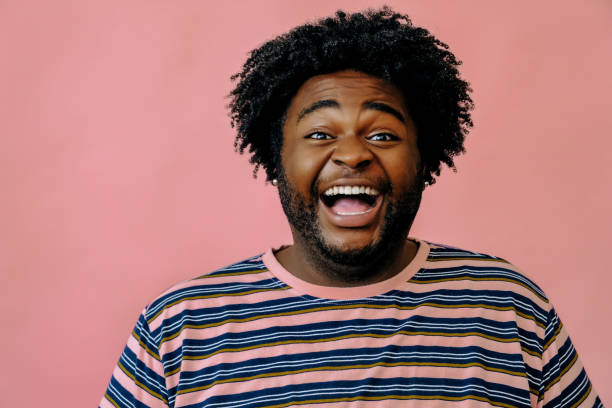 istock young happy african american man posing in the studio over pink background 1367902532