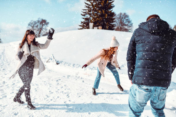 istock Snowball Fight By Smiling Friends On Mountain Summit 1367902536