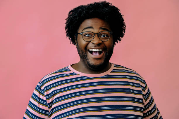 istock young happy african american man posing in the studio over pink background 1367902537