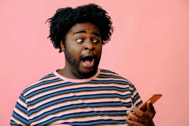 istock young happy african american man posing in the studio over pink background 1367902540
