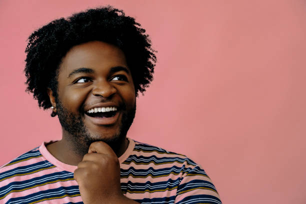 istock young happy african american man posing in the studio over pink background 1367902582