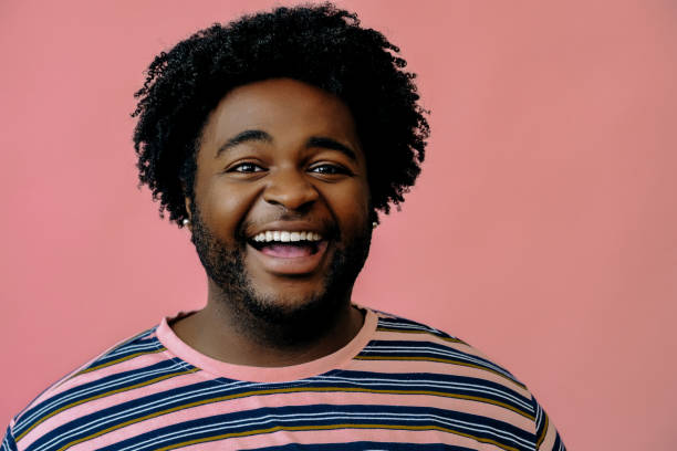 istock young happy african american man posing in the studio over pink background 1367902599
