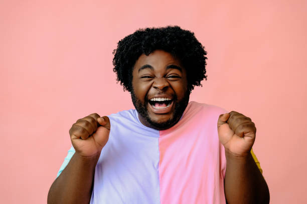 istock young happy african american man posing in the studio over pink background 1367904163