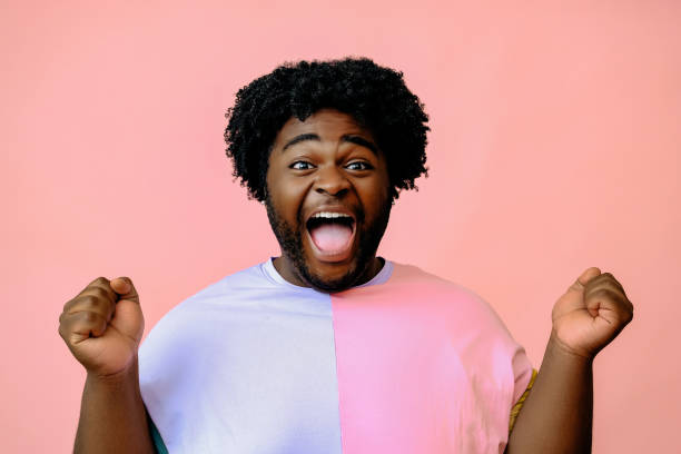 istock young happy african american man posing in the studio over pink background 1367904185