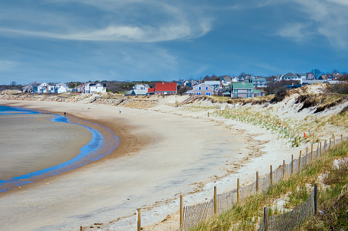 The expansive sand flats of Corporation Beach in Dennis, Massachusetts are revealed with the low tide.  Many of the seaside cottages are still boarded up awaiting the summer season.