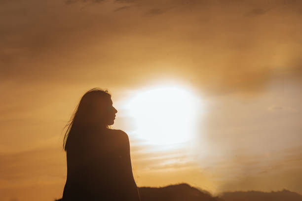 istock Young beautiful girl in the setting sun 1367905450