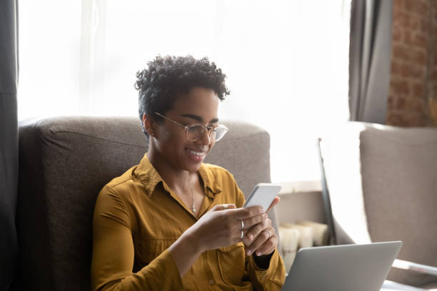 istock Distracted happy young African American woman using smartphone. 1367907008