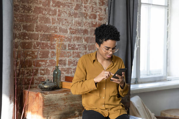 istock Happy millennial African American woman using cellphone. 1367907043