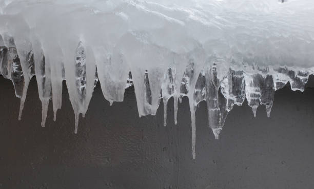 istock melting icicles on a gray wall. Nature background 1367907085