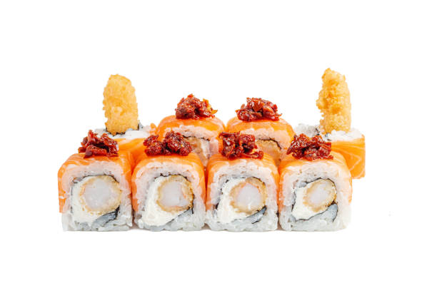 istock Roll completely wrapped in salmon with fried shrimp, cream cheese and sun-dried tomatoes, topped with kabayaki sauce in a plate on a white isolated background 1367908990