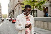 istock Young African-American man uses a mobile phone on the go 1367909982