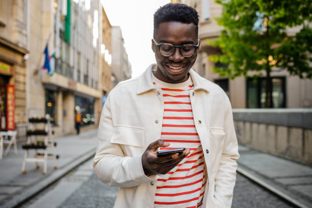 istock Young African-American man uses a mobile phone on the go 1367910315