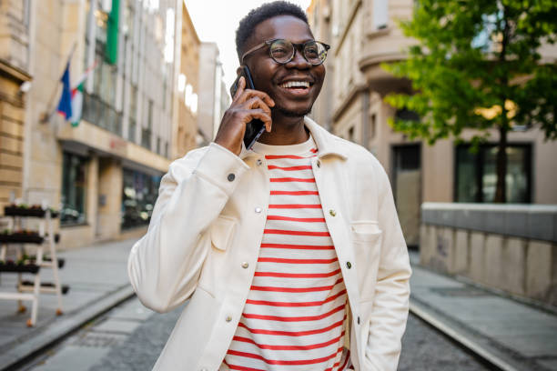 African-American confident young man talking on the phone on the street stock photo