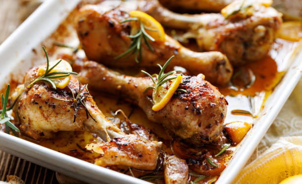 istock Roasted chicken legs drumsticks with rosemary, garlic and lemon in a ceramic baking dish 1367915148