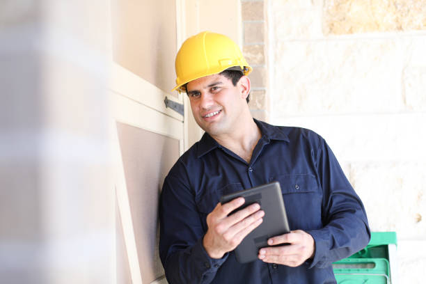istock Latin descent man inspects home exterior. Contractor, inspector. 1367917007