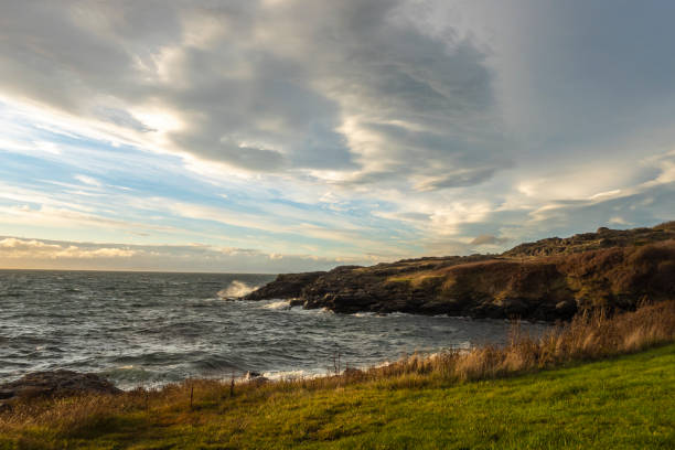 ワシントン州サンファン島の日没時に沿岸の岩に衝突する白い、泡立つ波 - water tranquil scene puget sound cloudscape ストックフォトと画像