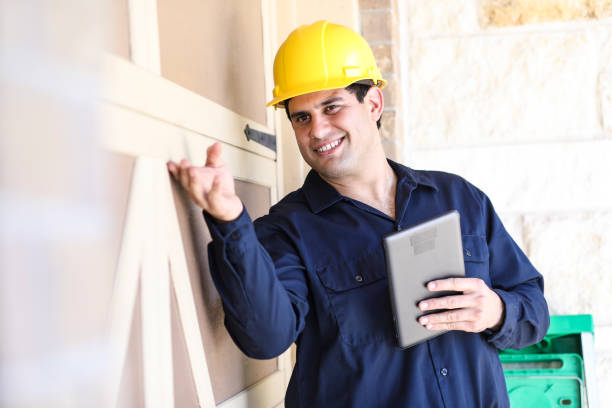 istock Latin descent man inspects home exterior. Contractor, inspector. 1367917067