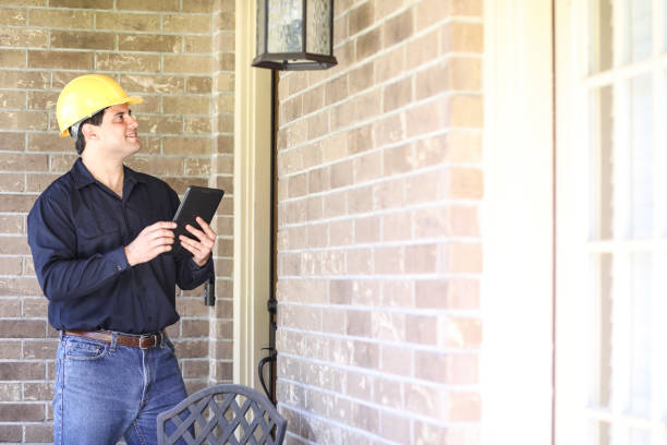 istock Latin descent man inspects home exterior. Contractor, inspector. 1367917214