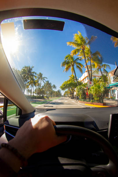 pov point de vue d’un jeune sportif conduisant une voiture devant un paysage marin bleu paradisiaque dans la région du district de miami beach, miami, floride du sud, états-unis d’amérique - états-unis - colony photos et images de collection