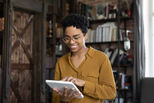 istock Smiling millennial African American woman using tablet. 1367920231
