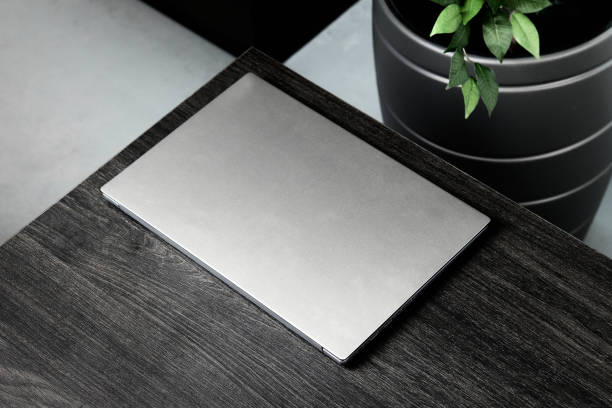 istock grey closed laptop on black wooden table, mockup 1367924231
