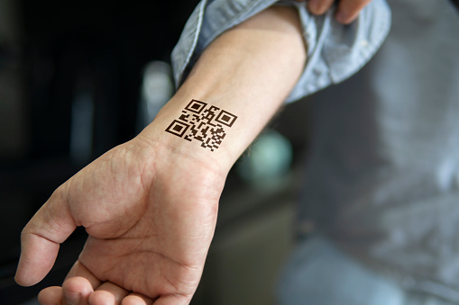 The man shows his hand with a qr code, a confirmation of the vaccination against the covid 19 coronavirus. Temporary tattoo on wrist, Carpus