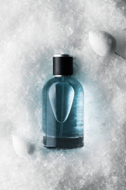 istock Perfume in spray bottle and decorative flower buds on white fluffy surface 1367926765