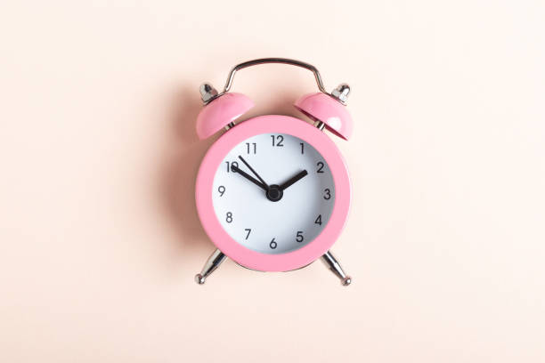 istock Little pink alarm clock on a pink background 1367926968