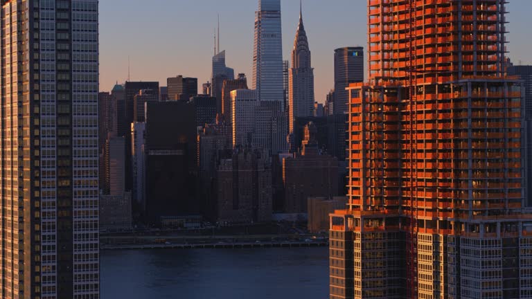 Aerial view of the residential waterfront in Long Island City, Queens, New York, with Midtown Manhattan skyline partially visible behind.
