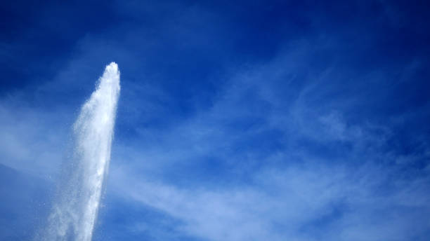 青空に対する背の高い間欠泉または噴水 - usa business success earth ストックフォトと画像