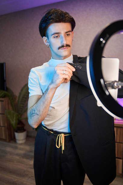 istock Metrosexual man showing to the camera his suit with serious face while recording his blo 1367930102