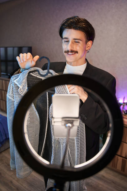 istock Man with mustache telling something and showing his clothes to the camera while recording video 1367930108