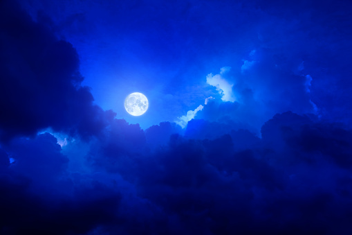 half waxing gibbous moon on dark blue sky