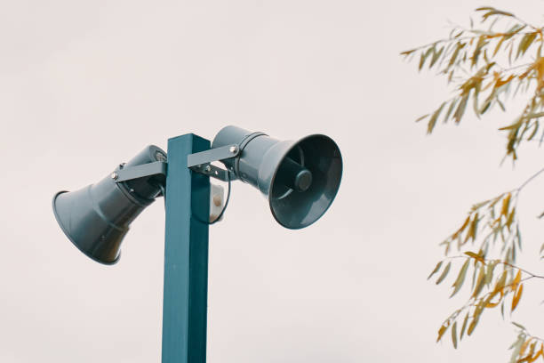 istock Tall column with two loudspeakers against cloudy sky. 1367937408